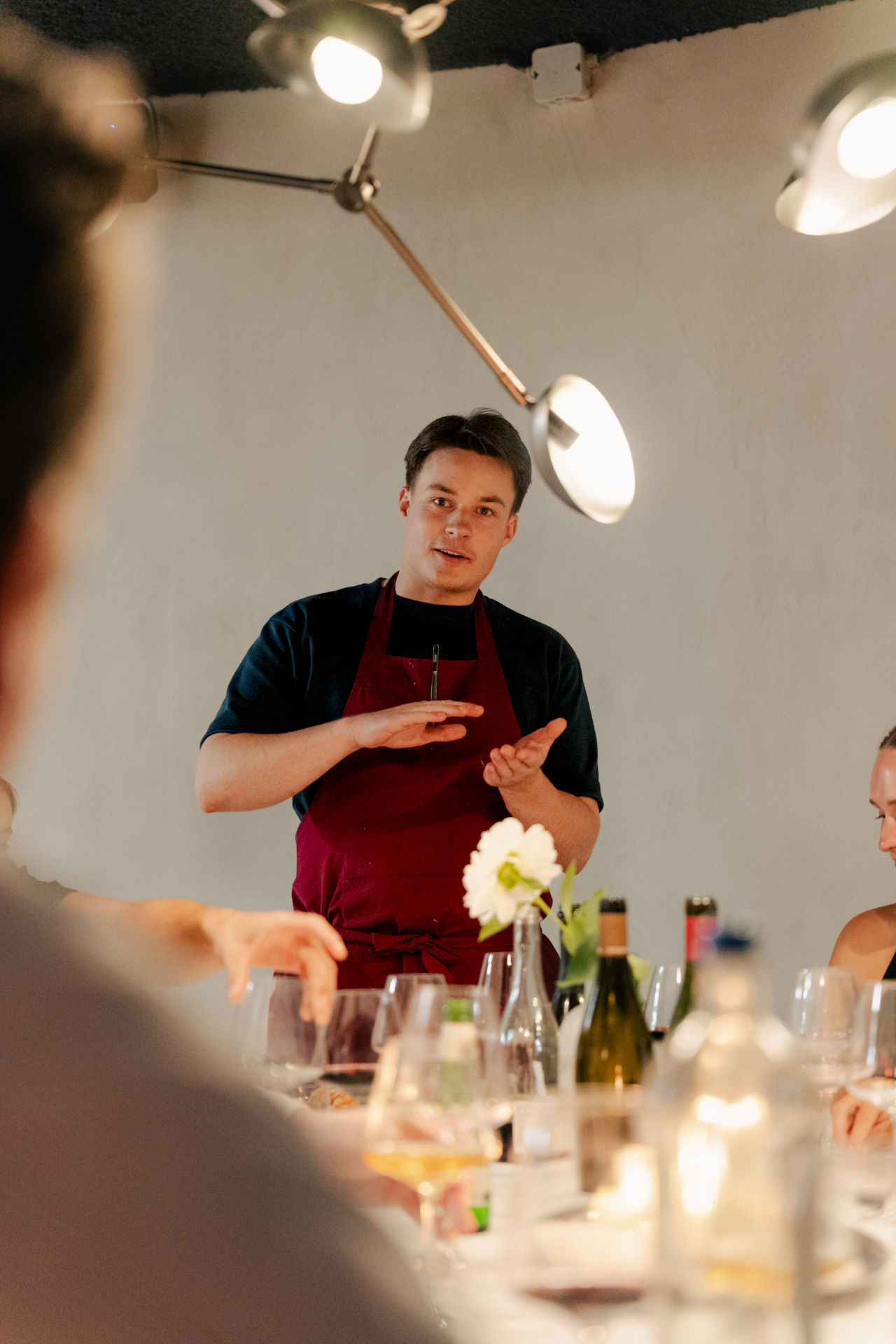 Chef Guillaume Andries speaking to guests at the table
